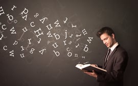 Casual young man holding book with white alphabet flying out of it